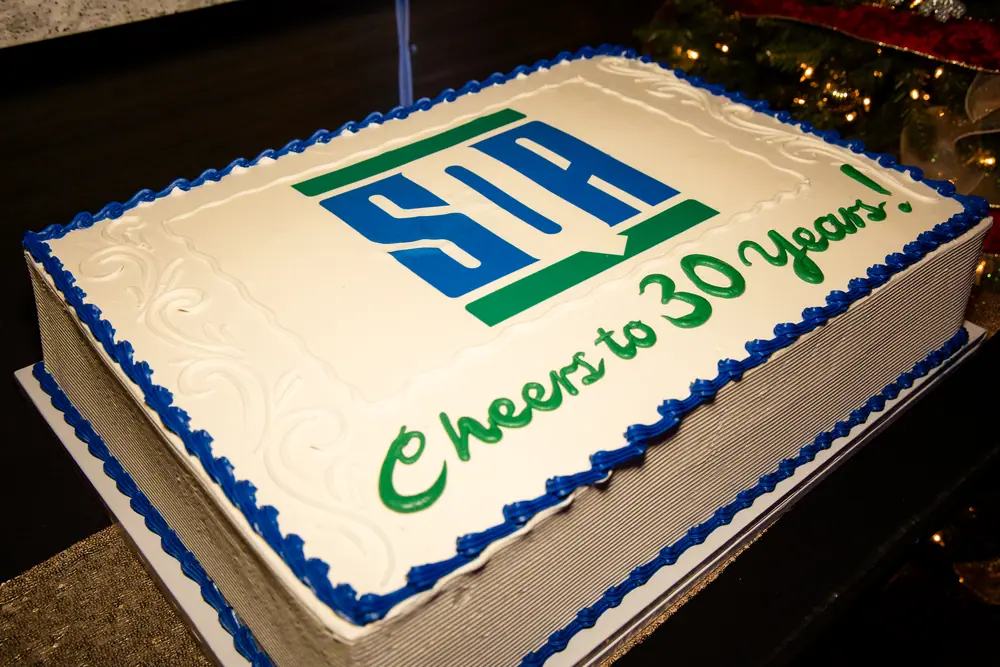A sheet cake iced with the SQA Services logo and the words Cheers to 30 Years